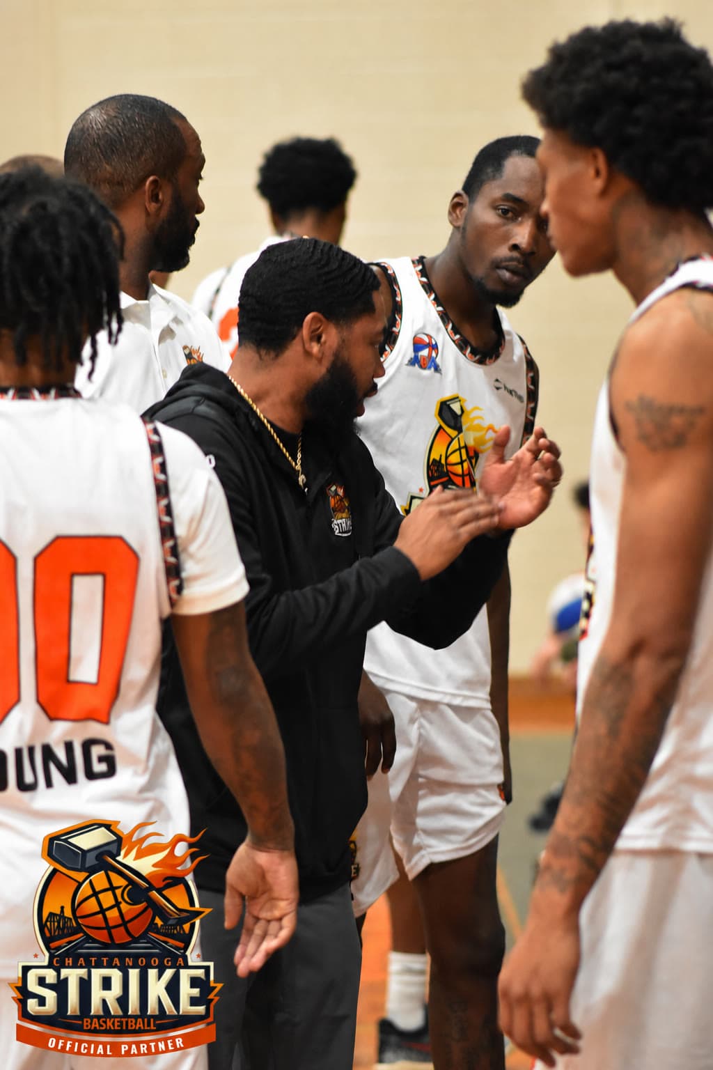 A Chattanooga Strike coach in a black hoodie talking with players during a game