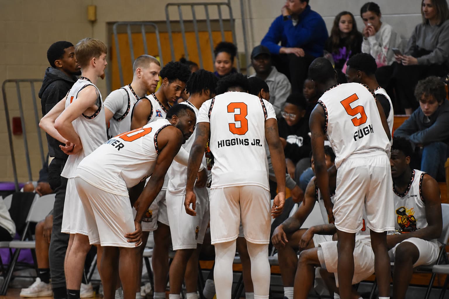 Chattanooga Strike players in a huddle, including Higgins Jr. and Fugh, with fans seated behind them